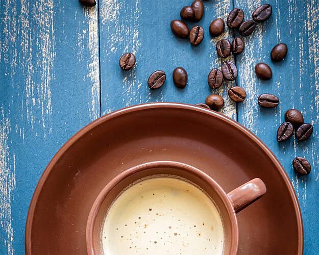 Kop kaffe set ovenfra med cremet kaffeskum – illustration til artikel om fakta om kaffe og koffeinens virkning.