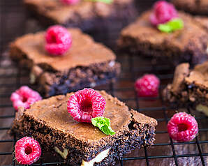 Brownie med hindbær pyntet med friske hindbær og hvid chokolade