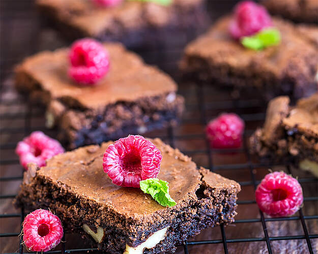 Brownie med hindbær pyntet med friske hindbær og hvid chokolade