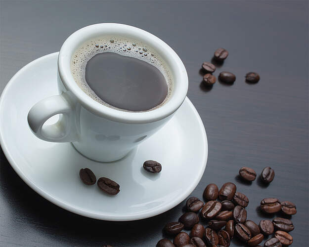 Kop kaffe med kaffebønner - illustration til artikel om koffeinens virkning