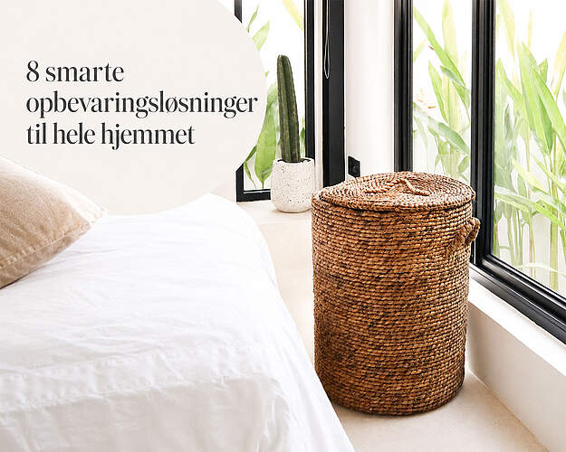 Flettet opbevaringskurv med låg ved seng og vindue
