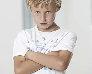 E-Guiden Livsstil – Dreng med korslagte arme symboliserer konflikt og opførsel ved gæstebud