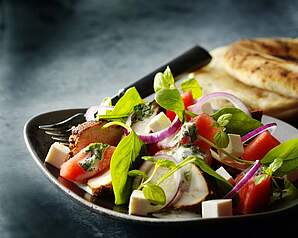 Salat med tandoori-stegt kylling, melon, babyspinat, rødløg og salatost