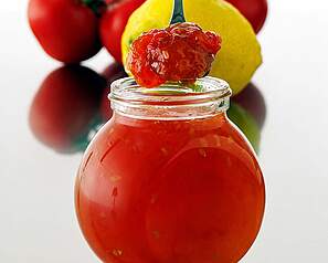 Tomatmarmelade i glas med citron og røde tomater